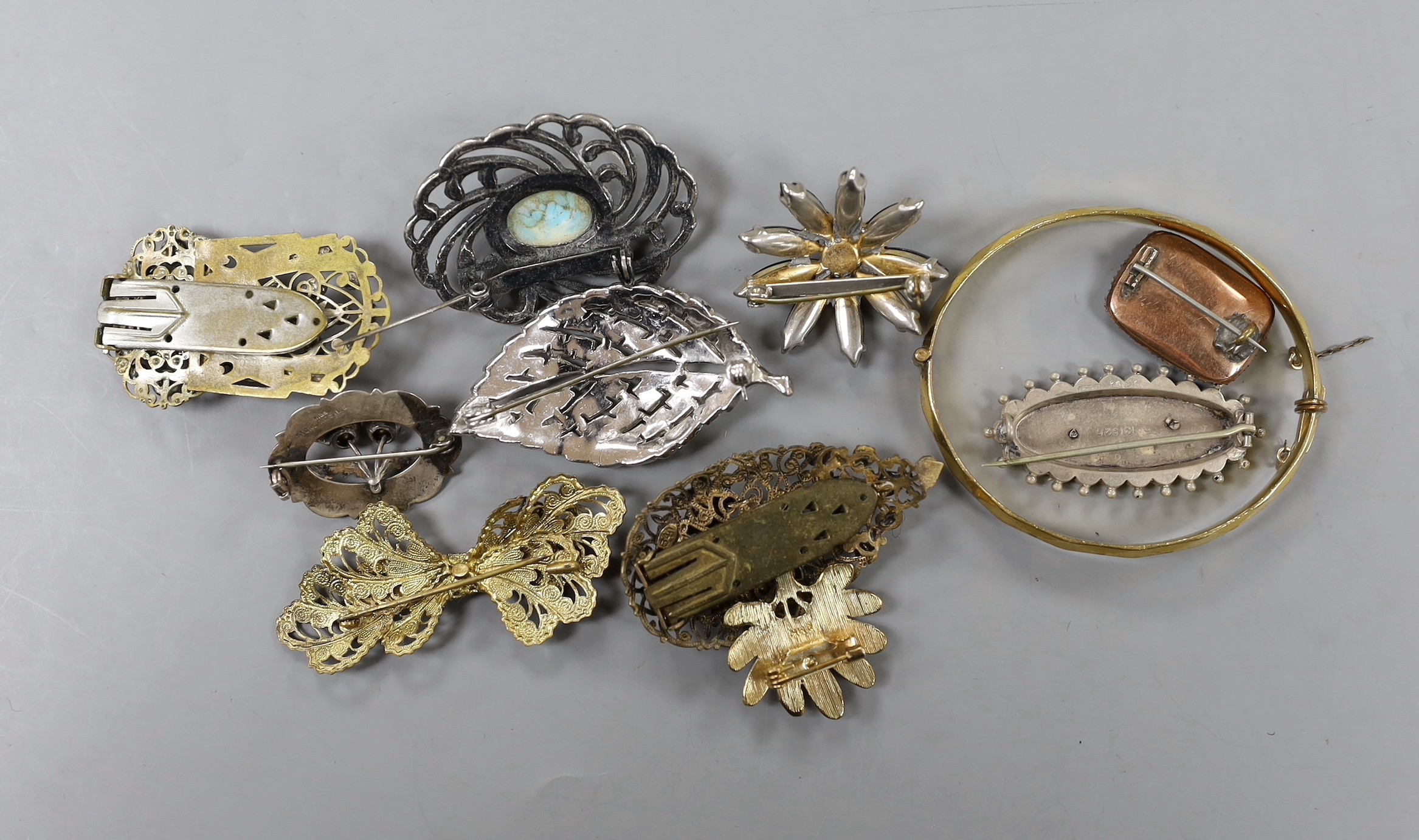 A Victorian yellow metal, split pearl and plaited hair set mourning brooch, 25mm, together with a late Victorian silver brooch, a sterling and two stone set brooch and eight items of costume jewellery.